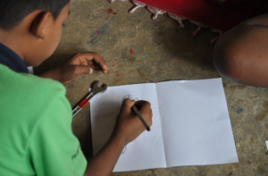 A boy makes a drawing of a wrench